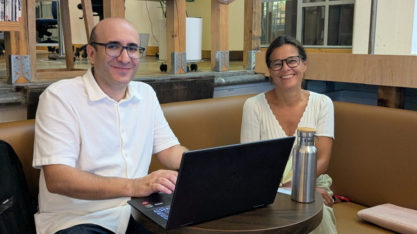 Une mentore bénévole Alter Start et un porteur de projet souriants autour d'un ordinateur portable